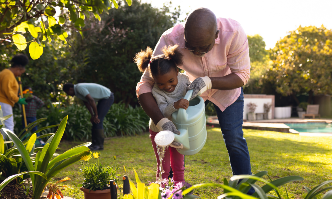 Father and daughter watering plants